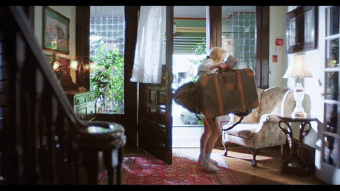 Women entering house with multiple suitcases and bags